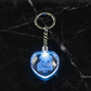 Heart-shaped keychain with a blue light on a dark marble surface