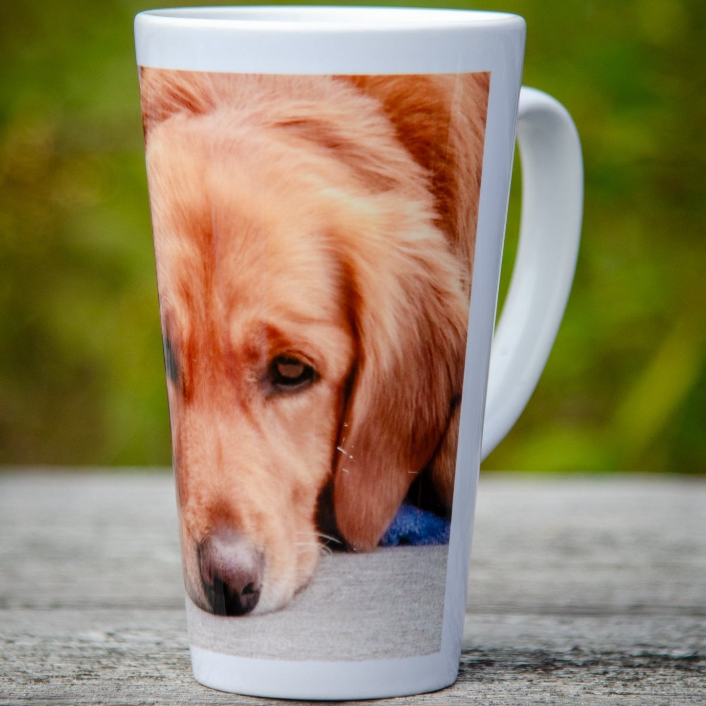 A white coffee mug with an image of a Golden Retriever dog's face on it.